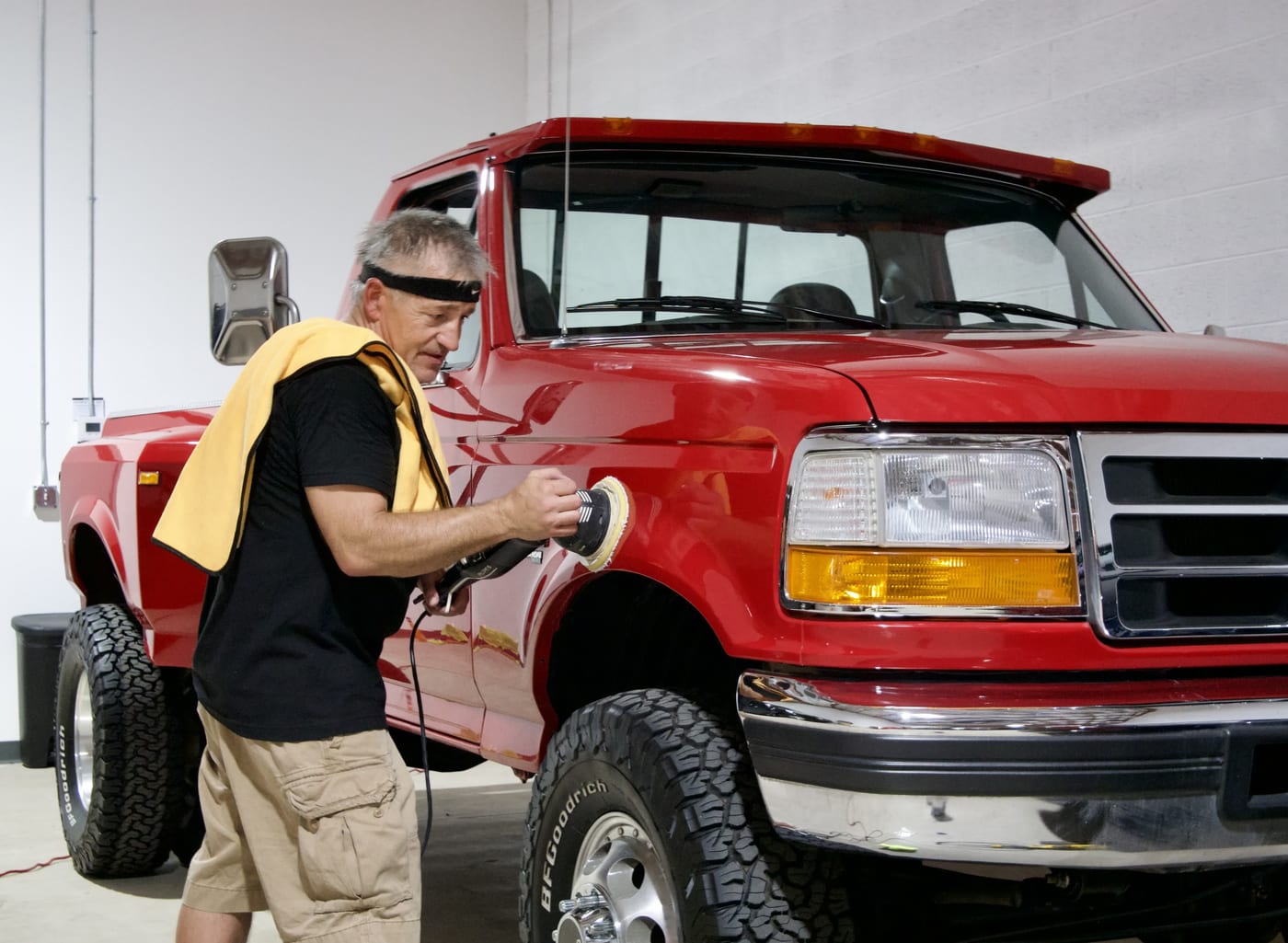 Mike polishing a lifted red Ford F-350
