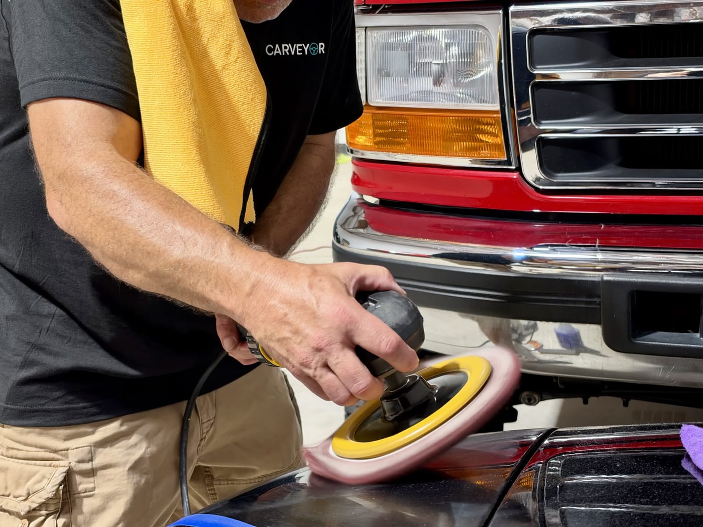 A dual-action polisher working a fender to a mirror finish